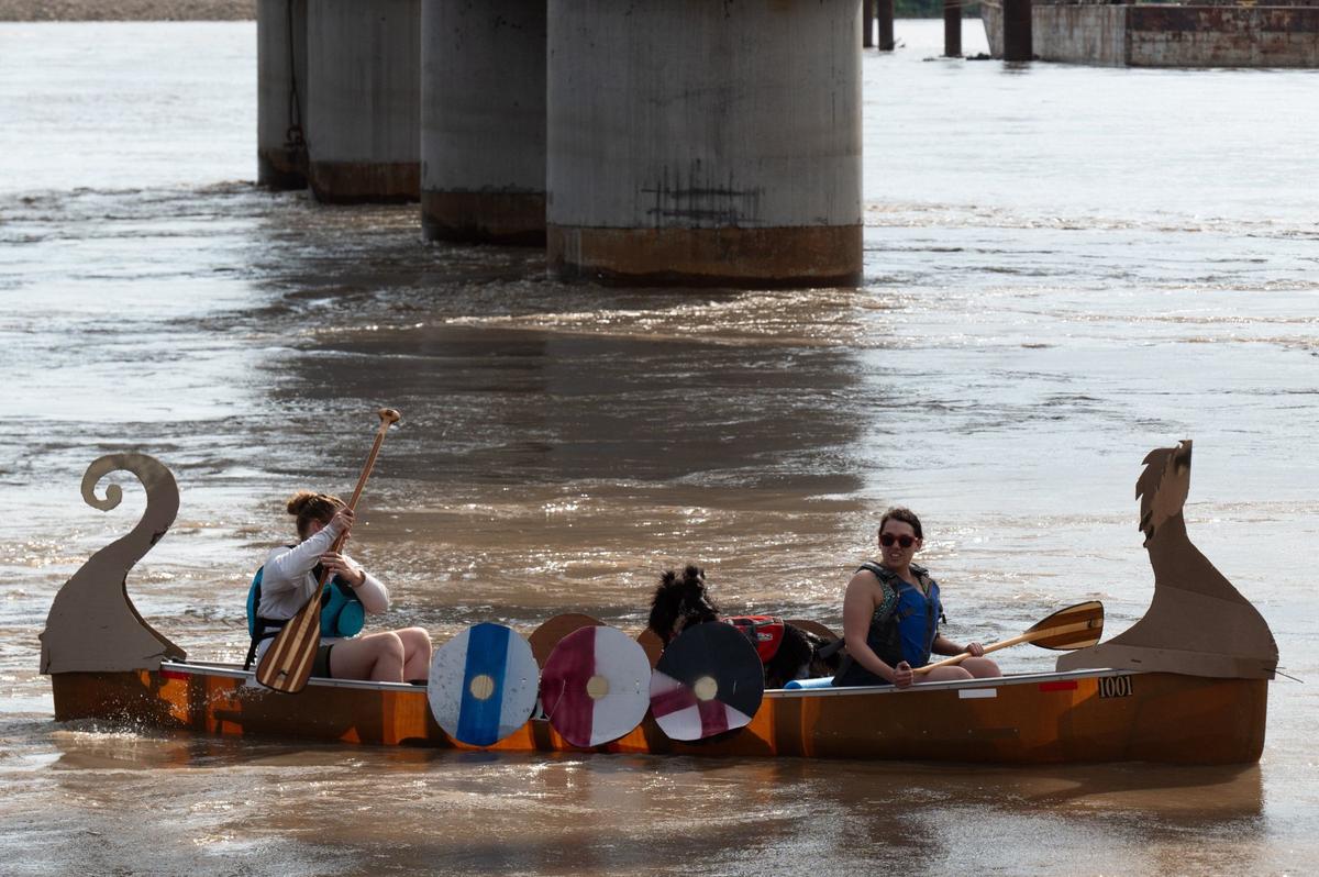 A boat made to look like a Viking longboat floats down the Missouri River with its crew Saturday during the Kawsmouth River Carnival.