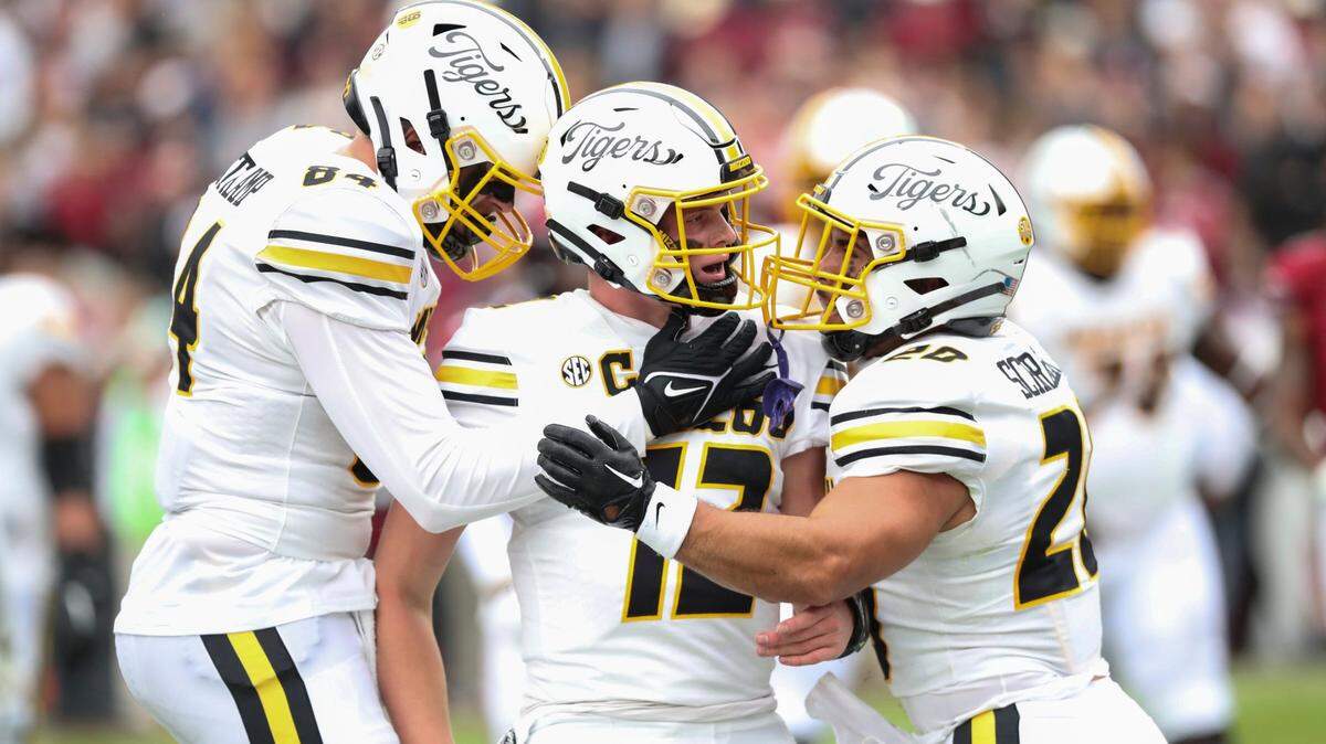 Missouri quarterback Brady Cook is surrounded by happy teammates after scoring a touchdown against the Gamecocks on Saturday in Columbia, S.C. (AP photo)