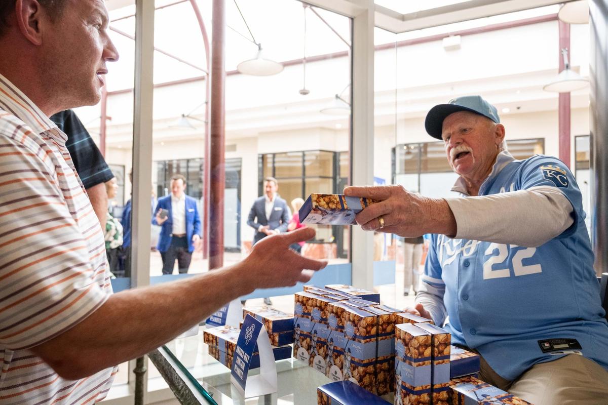 Royals Hall of Fame pitcher Dennis Leonard signs boxes of popcorn for fans at the Royals’ Crowning Achievements Exhibit at Commerce Bank in downtown Kansas City on Tuesday.