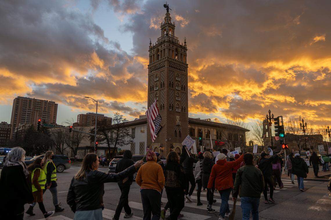 Demonstrators cross Mill Creek Parkway near the Country Club Plaza during a vigil for victims of U.S. Immigration and Customs Enforcement on Saturday, Jan. 10, 2026, in Kansas City.