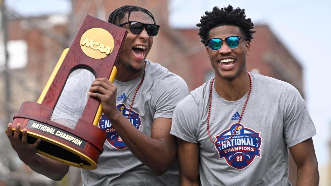 David McCormack holds the NCAA championship trophy as he and teammate Ochai Agbaji enjoy the Jayhawks parade in Lawrence last Sunday afternoon.