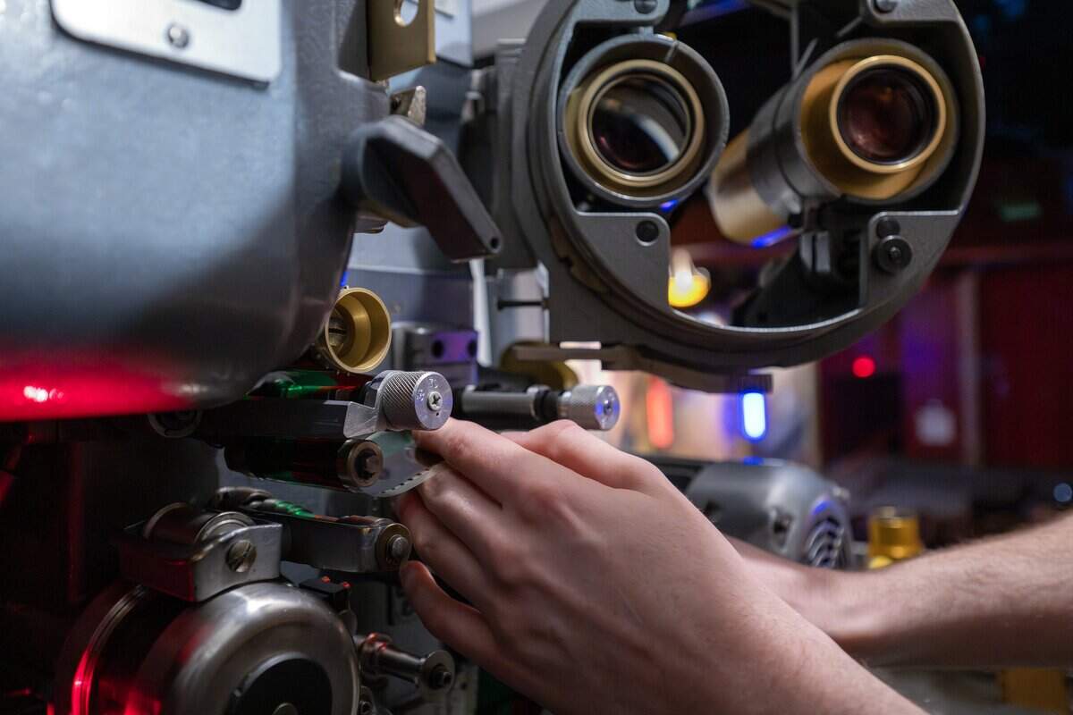 Projectionist Ethan Foster adjusts 70mm film for a screening of “Sinners” at Screenland Armour Theatre on Friday, March 27, 2026, in North Kansas City.