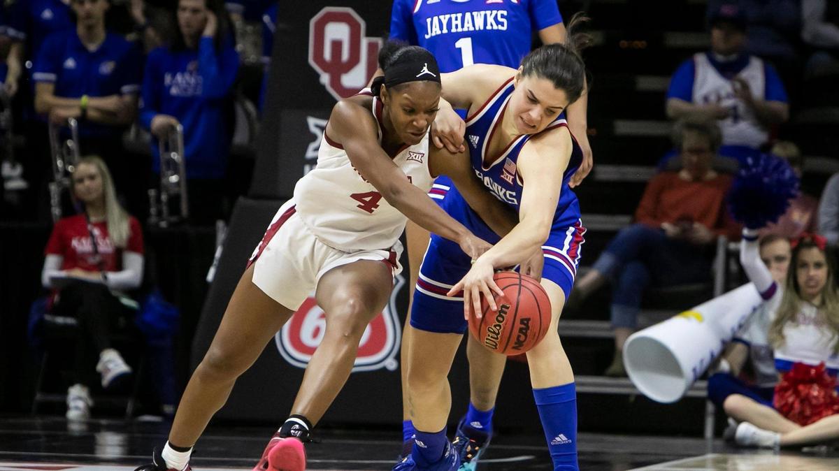 Kansas guard Mia Vuksic (4) attempts to knock the ball away from Oklahoma guard Kennady Tucker (4) during their Big 12 Tournament game on March 11, 2022 at Municipal Auditorium in Kansas City.