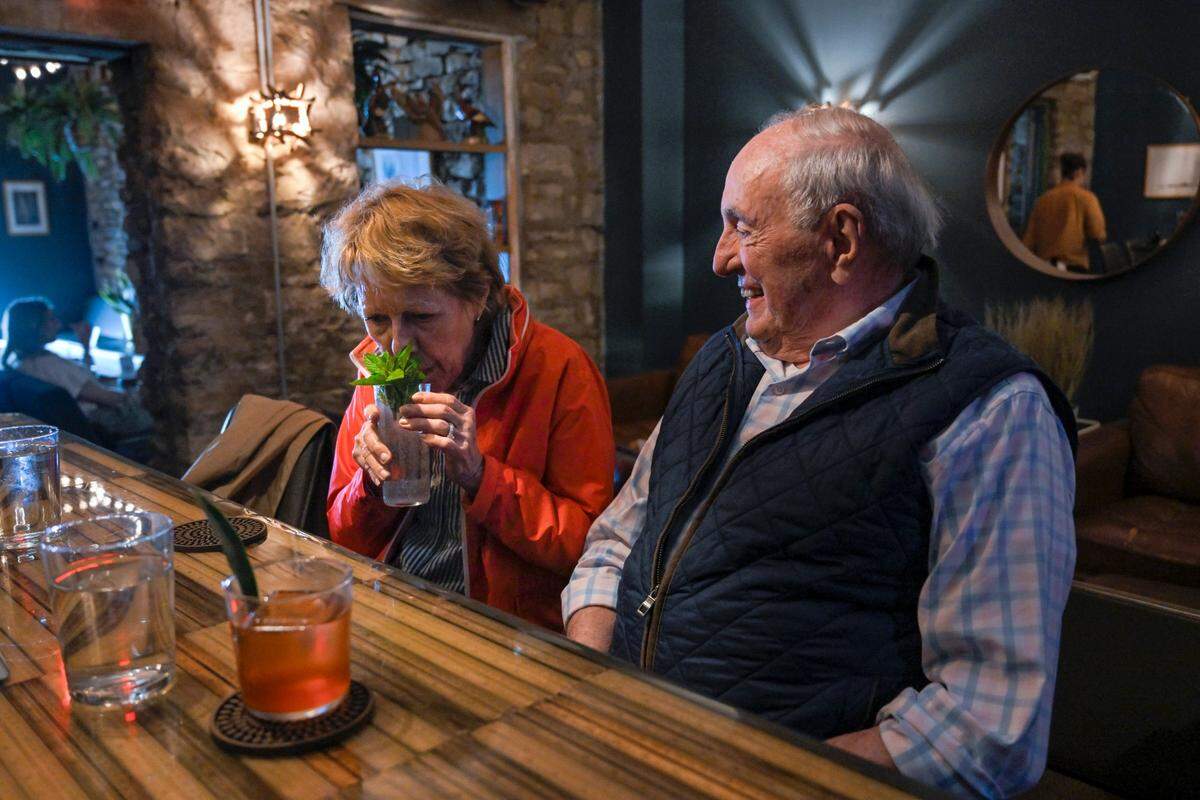 Susan Masson takes a whiff of her cocktail garnish as husband Alex Masson looks on from one of six seats at Drastic Measures’ small bar. Drastic Measures is one of five finalists in the Outstanding Bar category for the 2023 James Beard Awards. 