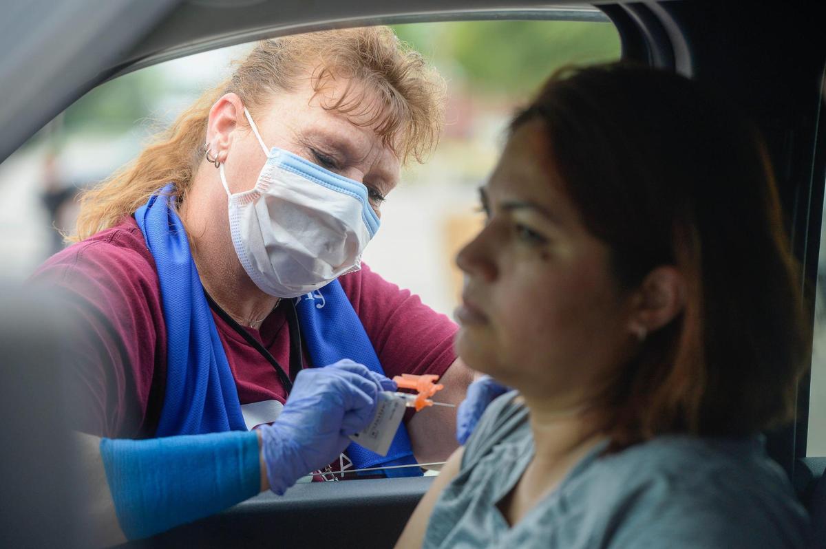 Guadalupe Abelino, front, 40, receives her COVID vaccine shot from medical assistant Sherry Rider, back, at a community vaccination event at Swope Heath West on State Avenue in Kansas City, Kansas on Saturday, July 31, 2021.