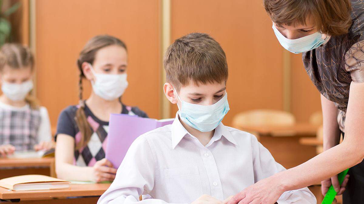 School children wear protective masks against coronavirus during a classroom lesson.