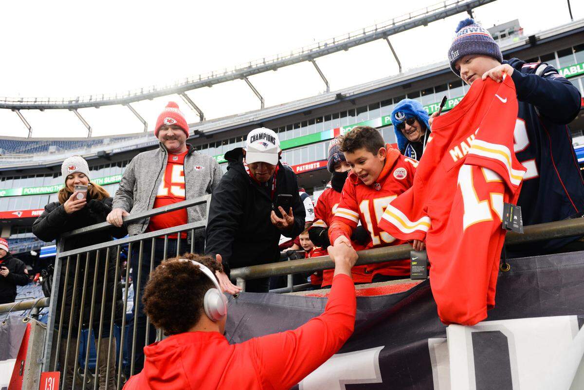 Patrick Mahomes #15 of the Kansas City Chiefs shakes the hand of a young fan prior to the start of the game against the New England Patriots at Gillette Stadium on December 8, 2019 in Foxborough, Massachusetts.