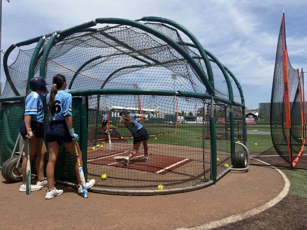 KC Diamonds infielder Alex Brown practices her hitting as infielders Allie Skaggs and Presleigh Pilon watch off to the side during an open women’s pro softball practice at Legends Field in Kansas City, Kansas, on Tuesday, June 2, 2026.