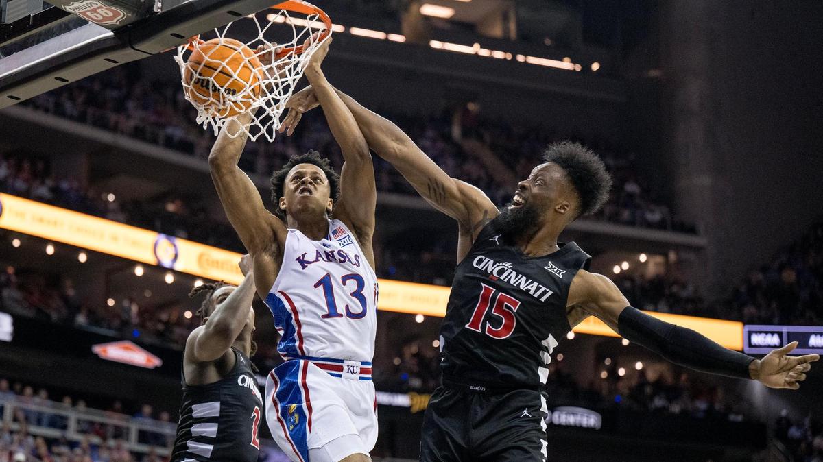 Kansas Jayhawks guard Elmarko Jackson (13) dunks the ball between Cincinnati Bearcats guard Jizzle James (2) and forward John Newman III (15) during an NCAA basketball game in the Big 12 men’s basketball tournament on Wednesday, March 13, 2024, in Kansas City.