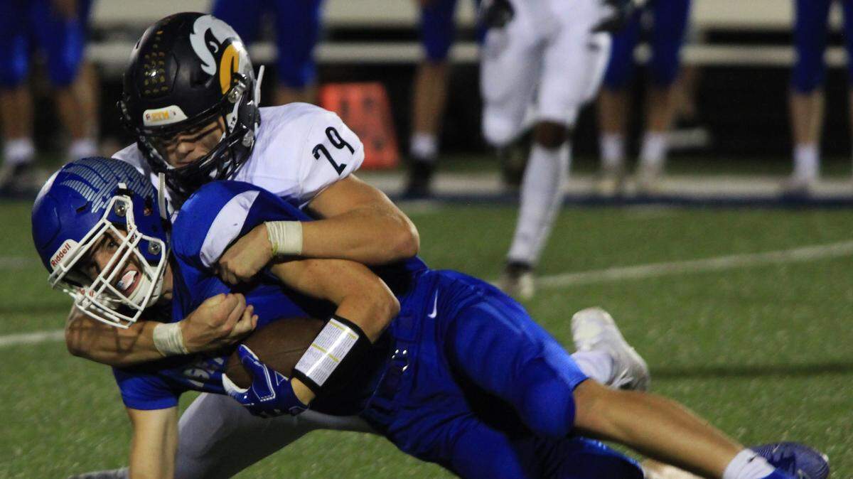 Liberty North’s Connor Baxley brings down Caleb Cahill of Liberty late in Friday’s night’s game at Liberty. The Eagles’ defense held Liberty to just a field goal in their 14-3 win.