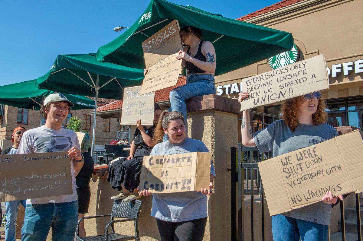 Starbuck employees picket at the Starbucks location on the Country Club Plaza on Tuesday, Aug. 23, 2022. The store abruptly closed Monday afternoon notifying employees and guests that the location had permanently closed according to signs posted on the doors.