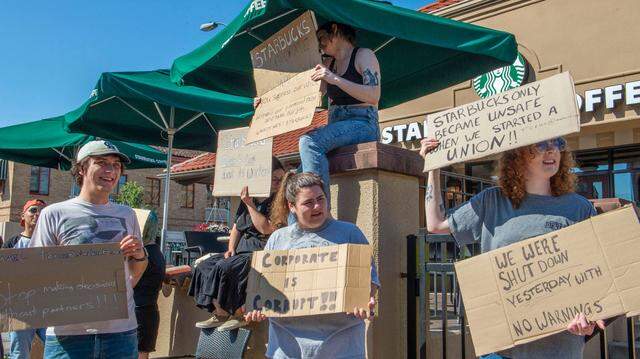 Starbucks employees picket at the coffee chain’s Country Club Plaza location Tuesday in Kansas City. Workers said they believed the closure was related to their recent efforts to form a union.