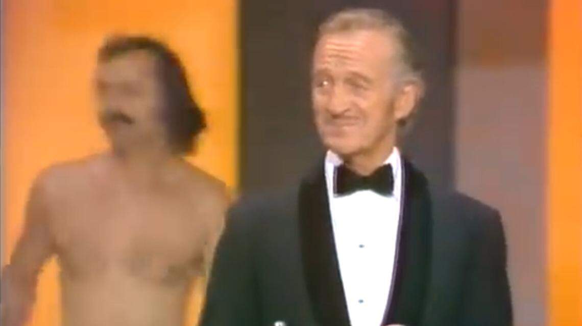 Host David Niven gets a surprise while introducing Elizabeth Taylor at the 46th Academy Awards.