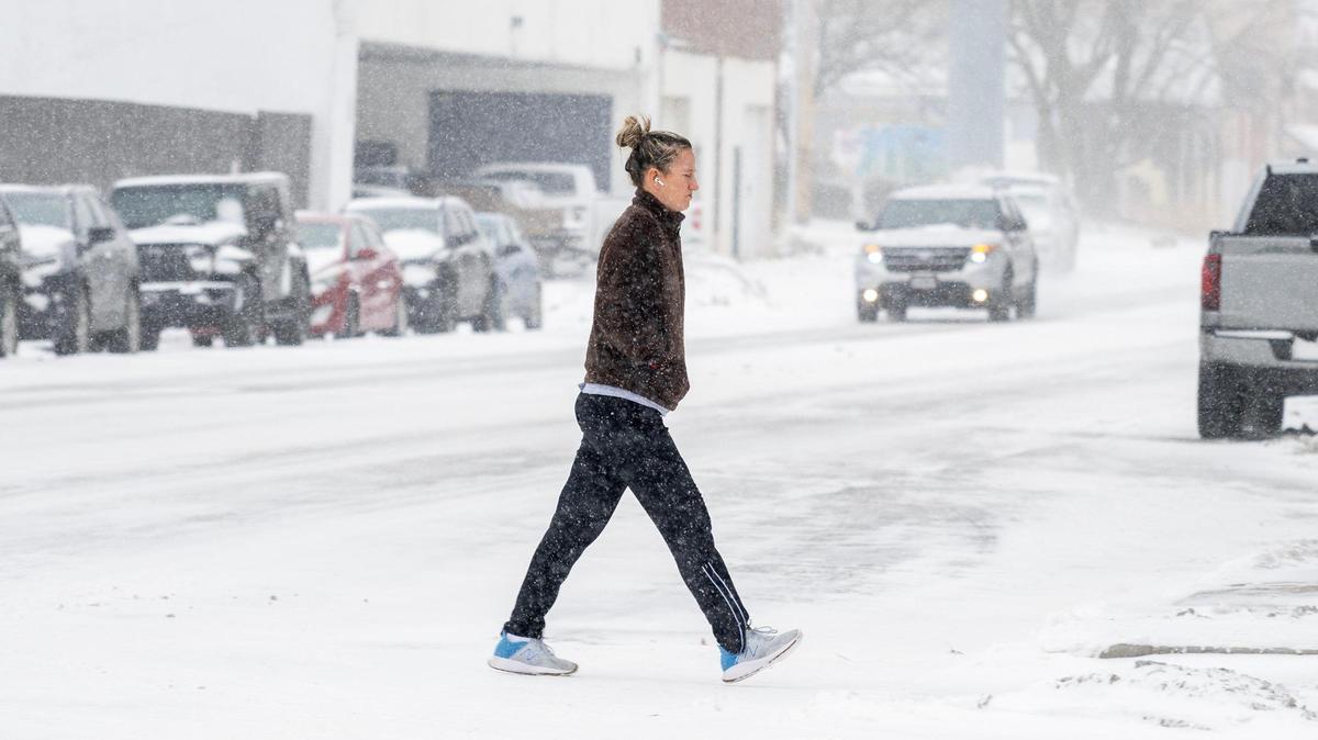 A pedestrian makes their way along Troost Avenue as heavy snow fell Tuesday in Kansas City.
