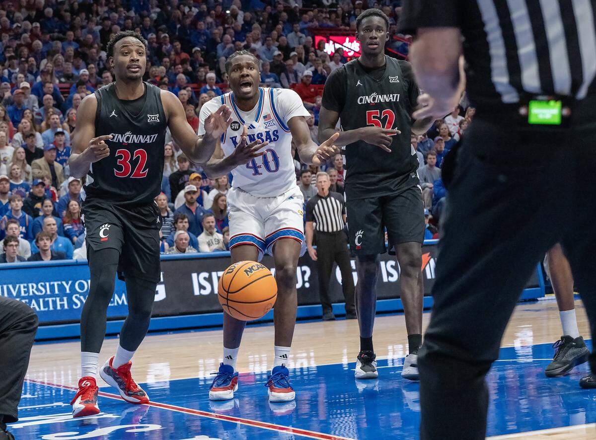 Kansas Jayhawks forward Flory Bidunga (40) reacts to a call as does Cincinnati Bearcats forward Jalen Celestine (32) and Cincinnati Bearcats center Moustapha Thiam (52) in the second half Allen Fieldhouse on Saturday, Feb. 21, 2026, in Lawrence, Kansas.