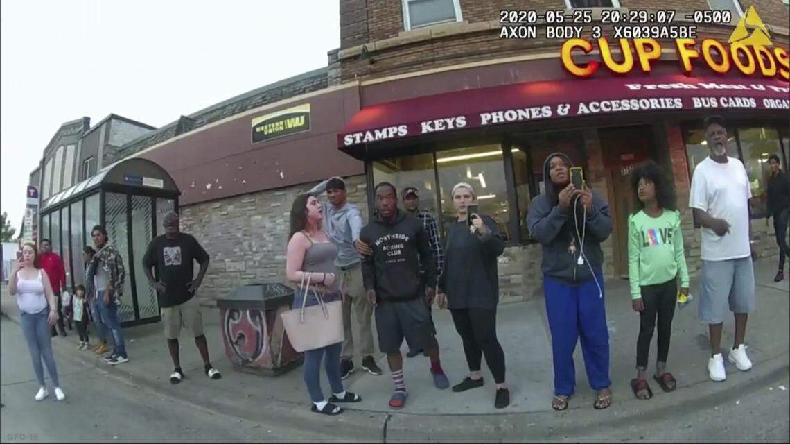 FILE - This May 25, 2020, file image from a police body camera shows bystanders including Alyssa Funari, left filming, Charles McMillan, center left in light colored shorts, Christopher Martin center in gray, Donald Williams, center in black, Genevieve Hansen, fourth from right filming, Darnella Frazier, third from right filming, as former Minneapolis police officer Derek Chauvin was recorded pressing his knee on George Floyd’s neck for several minutes in Minneapolis. To the prosecution, the witnesses who watched Floyd’s body go still were regular people -- a firefighter, a mixed martial arts fighter, a high school student and her 9-year-old cousin in a T-shirt emblazoned with the word “Love.” (Minneapolis Police Department via AP, File)