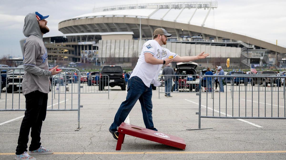 Micah Caldarella, left, and Jasen Sebelien play a game of corn hole before an opening day baseball game between the Kansas City Royals and the Minnesota Twins at Kauffman Stadium, Thursday, March 30, 2023, in Kansas City.