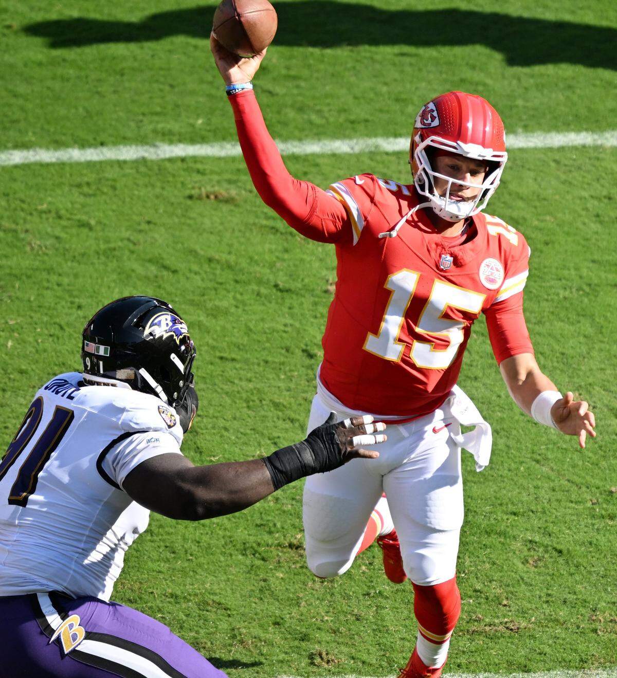 Kansas City Chiefs quarterback Patrick Mahomes (15) throws while being pressured by the Baltimore Ravens defense in the second quarter on Sunday, Sept. 28, 2025, at GEHA Field at Arrowhead Stadium.