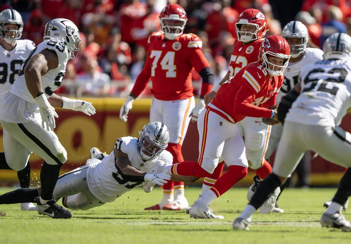 Las Vegas Raiders defensive end Malcolm Koonce (51) holds the leg of Kansas City Chiefs quarterback Patrick Mahomes (15) who scrambled during the first half on Sunday, October 19, 2025, at GEHA Field at Arrowhead Stadium in Kansas City. 