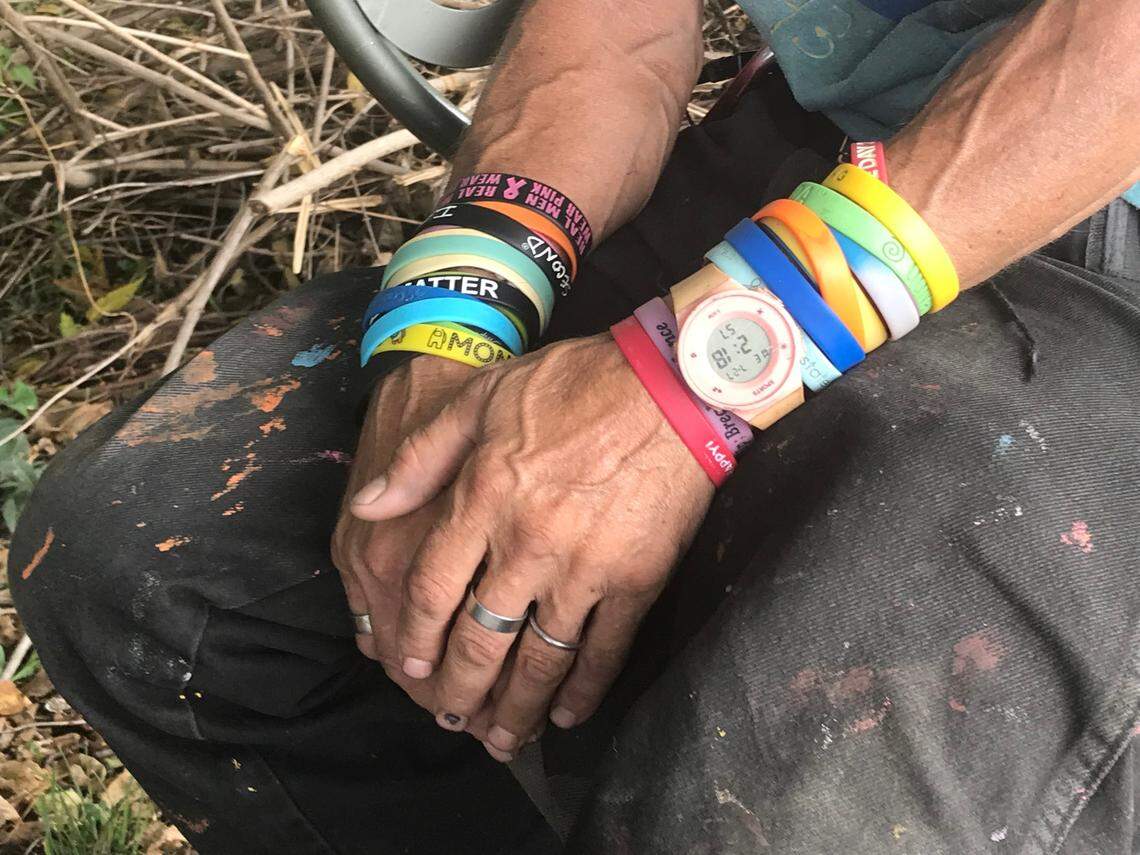 Jerry Crowell wears around twenty rainbow-colored rubber bracelets outside A Splash of Life, his informal donation distribution center on Troost Ave, on Wednesday, July 27.