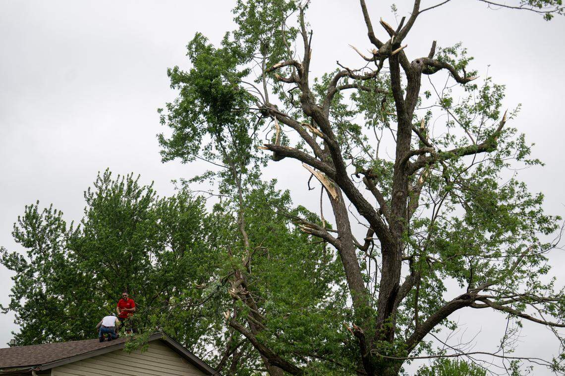 Men inspect a roof as cleanup efforts were underway in the 600 block of East Bodine St., in Clinton Missouri, on Thursday, April 16, 2026, after a tornado touched down in Henry County late Wednesday afternoon.