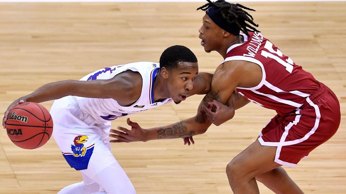 KU’s Bryce Thompson drives around OU’s Alondes Williams during the first half of a 2021 Big 12 Conference men’s basketball tournament game at the T-Mobile Center in Kansas City.
