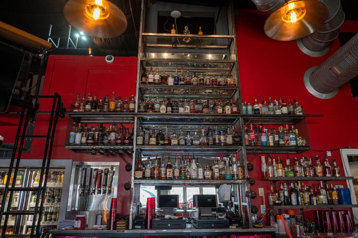 Bottles of liquor are stored on shelves in the bar area at F325 BBQ.