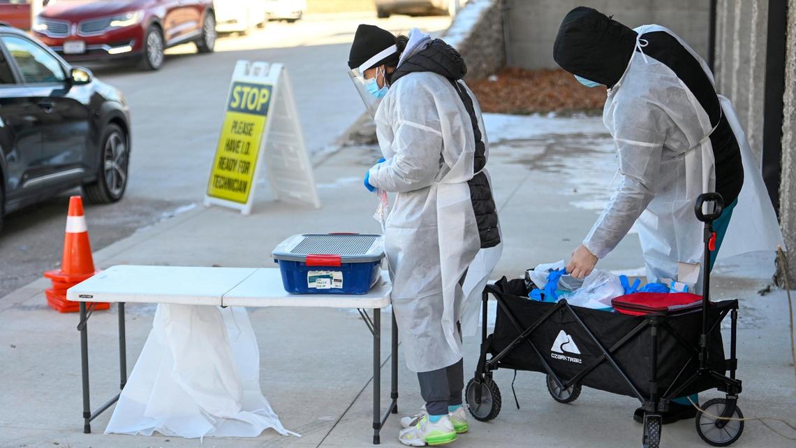 Despite the frigid temperatures, COVID-19 testing was underway at 7820 Prospect Ave., where McKayla Lee, left, and Mikey Boyer, both students at Missouri Southern State University, tested clients Friday, Jan. 7, 2022, during the drive-through clinic at the Heavy Construction Laborers parking lot in Kansas City. People being tested reported wait times of two hours or more to be tested.
