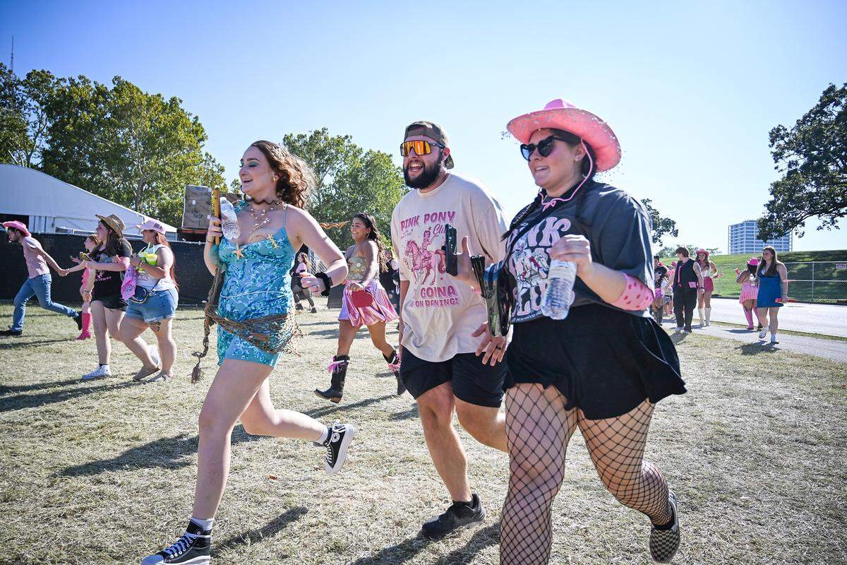 Fans run to first into the concert grounds before the Chappell Roan concert on Saturday, Oct. 4, 2025, at the National WWI Museum and Memorial in Kansas City.