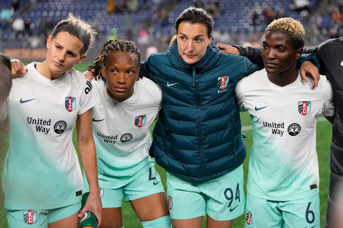 Kansas City Current players Bayley Feist (22), Gabrielle Robinson (24), Claire Lavogez (94) and Temwa Chawinga (6) huddle following the game against Seattle Reign FC at Lumen Field on May 8, 2024.