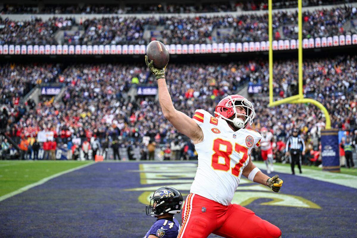 Kansas City Chiefs tight end Travis Kelce spikes the ball after coming down with a touchdown catch in front of Baltimore Ravens safety Kyle Hamilton in the first quarter on January 28, 2024, during the AFC Championship Game in Baltimore.