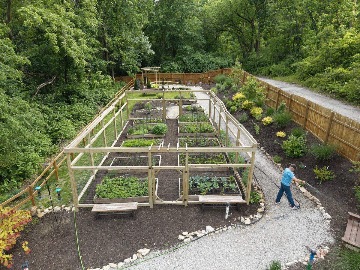 Paul Schnirch, 67, waters the community garden at Eden Village on Tuesday, May 12, 2026. Schnirch, a U.S. Army veteran and former mechanic, moved into the gated community at 1001 Metropolitan Ave. in July 2024. He said he inherited his mother's “green thumb” and enjoys the garden. The village provides permanent supportive housing for individuals transitioning from chronic homelessness.
