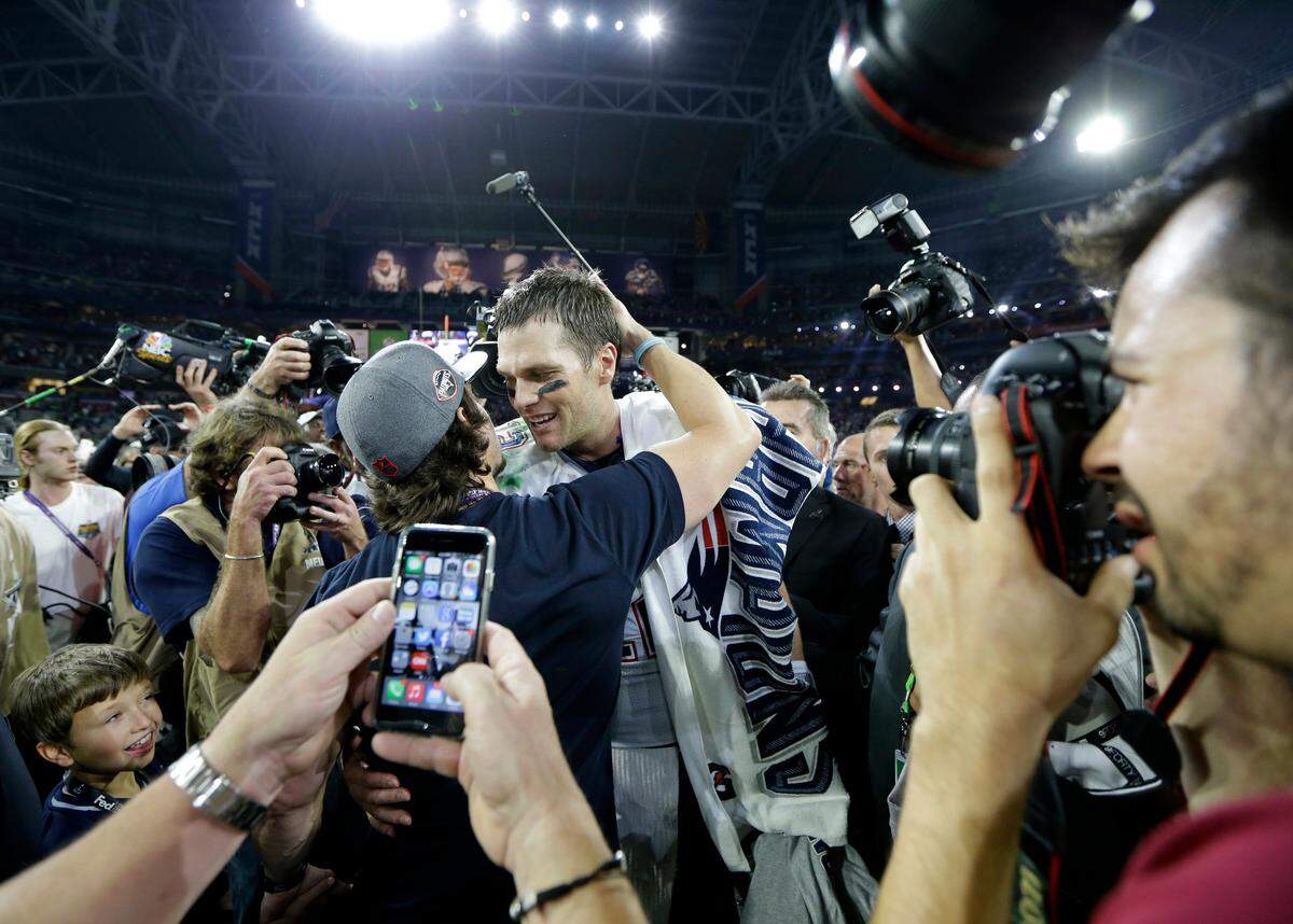 Actor Mark Wahlberg, left, hugs New England Patriots quarterback Tom Brady after the second half of NFL Super Bowl XLIX football game Sunday, Feb. 1, 2015, in Glendale, Ariz. (AP Photo/Mark Humphrey)
