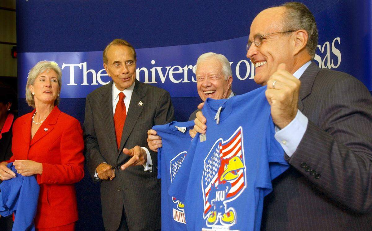 University of Kansas T-shirts were in vogue during a tribute to Bob Dole in Lawrence. Former New York City Mayor Rudy Giuliani (right) held up his T-shirt. Next to him stood former President Jimmy Carter. At left were Kansas Gov. Kathleen Sebelius and former Senator Dole.