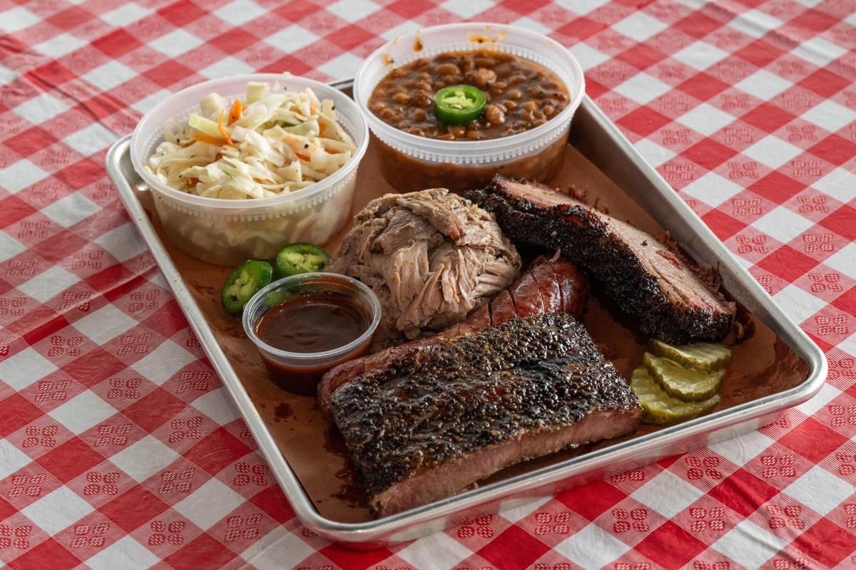 A mixed plate at Harp Barbecue included pork ribs, sausage, pulled pork, brisket, slaw, and beans. Owner Tyler Harp really likes his beans because they are more savory and most places do sweeter beans.” Harp Barbecue recently relocated to at a new location in Overland Park after starting in Raytown.