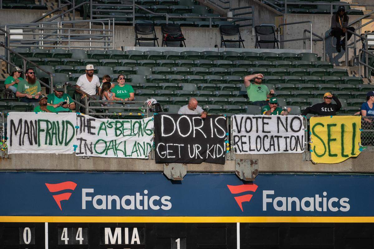 Oakland Athletics fans chant “sell the team” in the outfield during the first inning of the game against the Kansas City Royals at Oakland-Alameda County Coliseum.