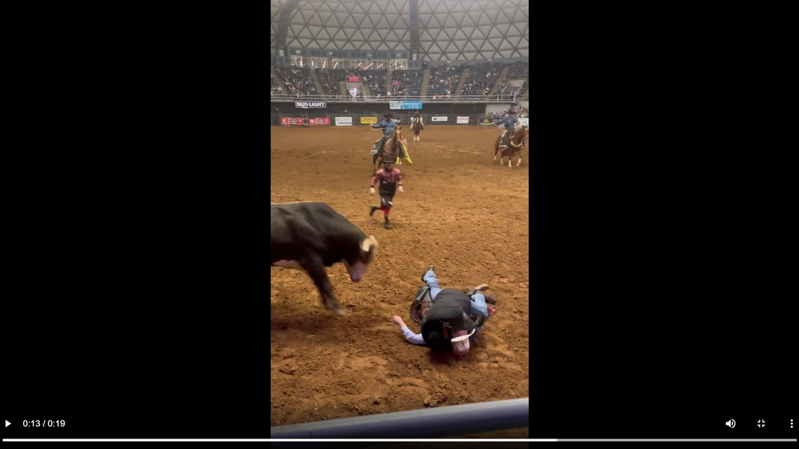 Father Landis Hooks is seen shielding his son Cody from a charging bull in a Texas rodeo arena.