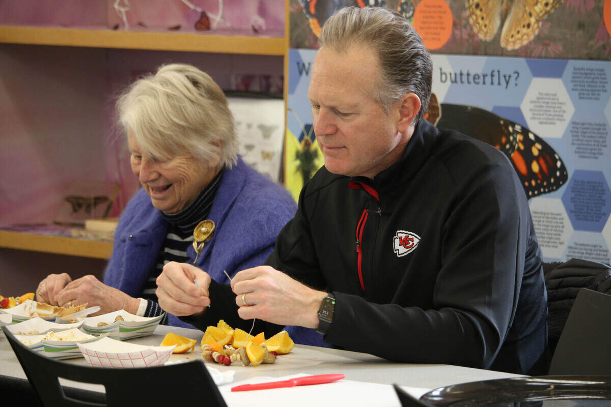 Marna Whitworth of Rhode Island and her son, Leawood resident Robert Andrews, work on making edible outdoor tree ornaments during a program at the Overland Park Arboretum.