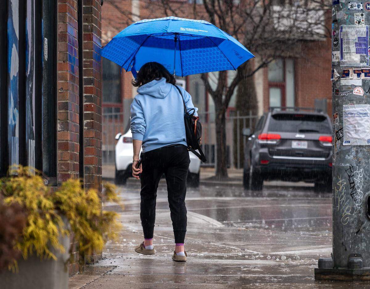 A pedestrian holds an umbrella while walking in the rain along Southwest Boulevard on Saturday, Feb. 14, 2026, in Kansas City.