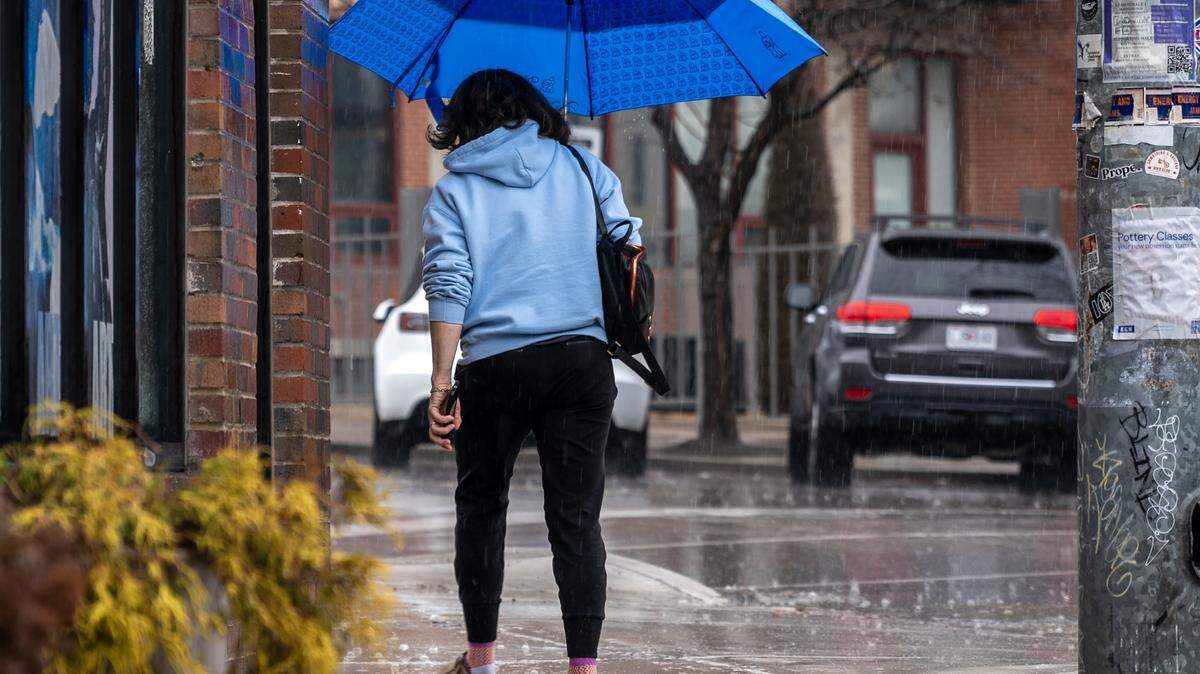 A pedestrian holds an umbrella while walking in the rain along Southwest Boulevard on Saturday, Feb. 14, 2026, in Kansas City.