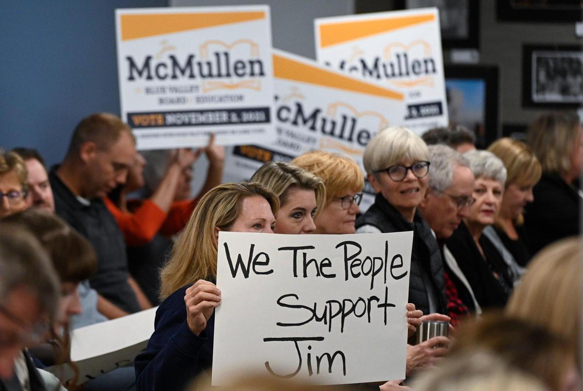 During a special meeting, residents held up campaign signs and homemade posters in support of Blue Valley school board member Jim McMullen, who has been under pressure to resign by many who deem his social media posts anti-LGBTQ.