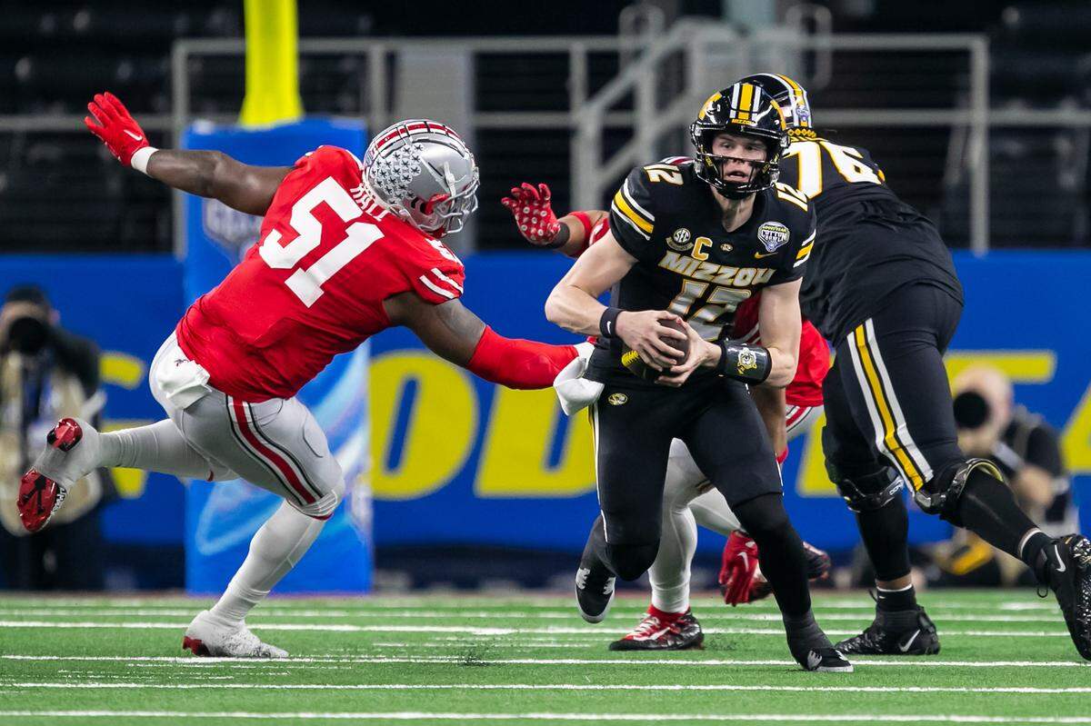 Missouri Tigers quarterback Brady Cook (No. 12) scrambles with the ball against Ohio State during the 88th annual Cotton Bowl on Friday at AT&T Stadium in Arlington, Texas.