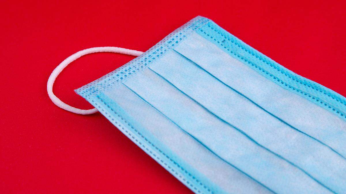 Medical protective face mask on red background coronavirus covid-19