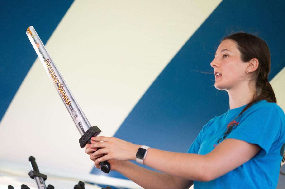 Paige Hunter wields a sword shaped sparkler while chatting with a customer on Tuesday at Pyro City Fireworks on Southwest Boulevard in Kansas City, Kansas.