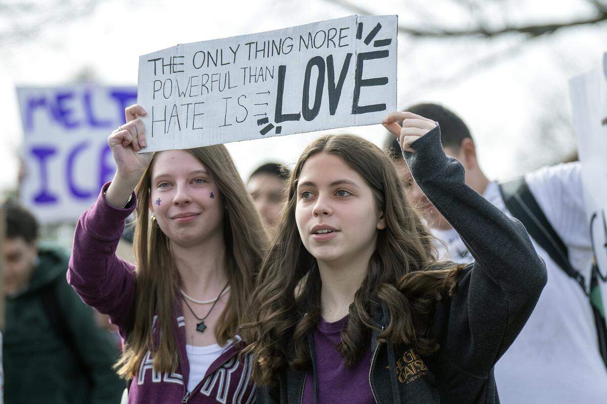 Echoing a powerful Super Bowl message, two Shawnee Mission North students hoist a sign declaring that love outweighs hate during Wednesday's protest against ICE and the Trump administration on Wednesday, February 11, 2026, in Overland Park.