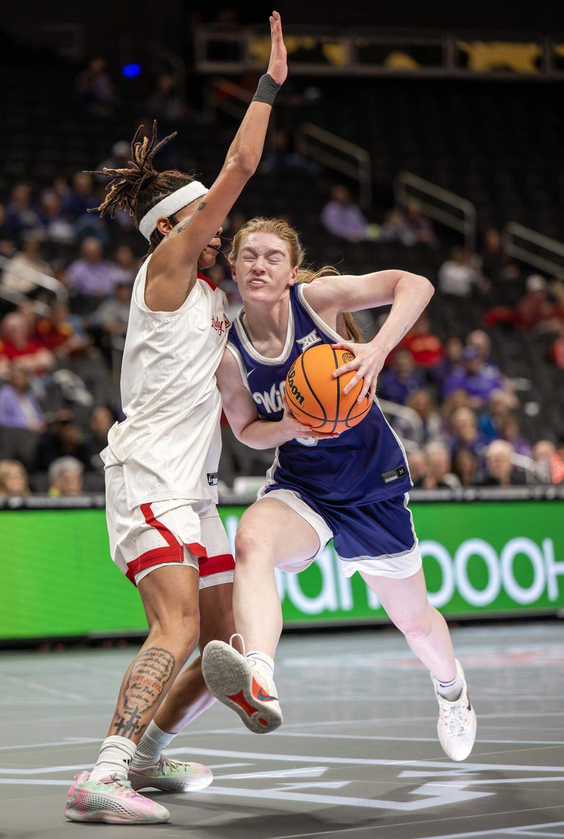 Kansas State Wildcats guard Tess Heal (34) drives past Texas Tech Red Raiders guard Snudda Collins (0) during a Big 12 Women's Basketball Tournament game at T-Mobile Center in Kansas City on Thursday, March 5, 2026.