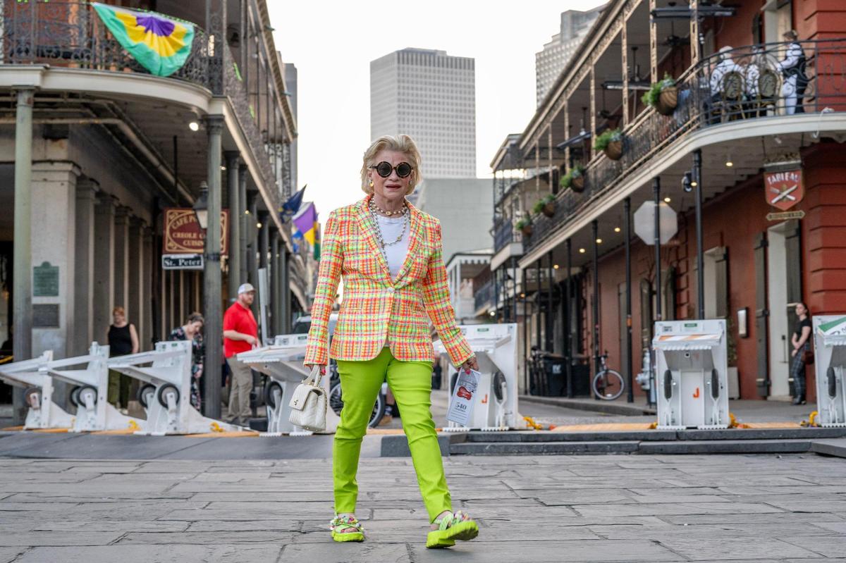 Sissy Sullivan, of New Orleans, wearing bright green pants, walks past St. Louis Cathedral on Wednesday, Feb. 5, 2025, in New Orleans.