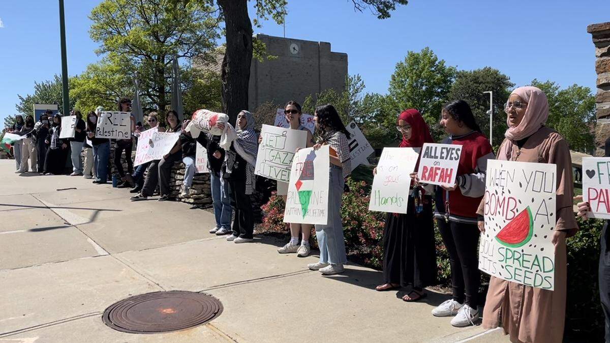 Students held signs Monday on the campus of the University of Missouri - Kansas City as college protests denouncing the war in Gaza spread across the country.