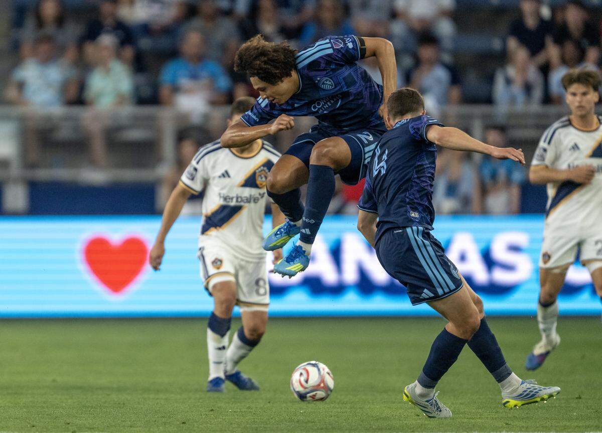 Sporting Kansas City defender Ian James (2) jumps over the ball past LA Galaxy midfielder Lucas Sanabria (8) in the first half at Sporting Park on Wednesday, May 13, 2026, 2026, in Kansas City, Kansas,
