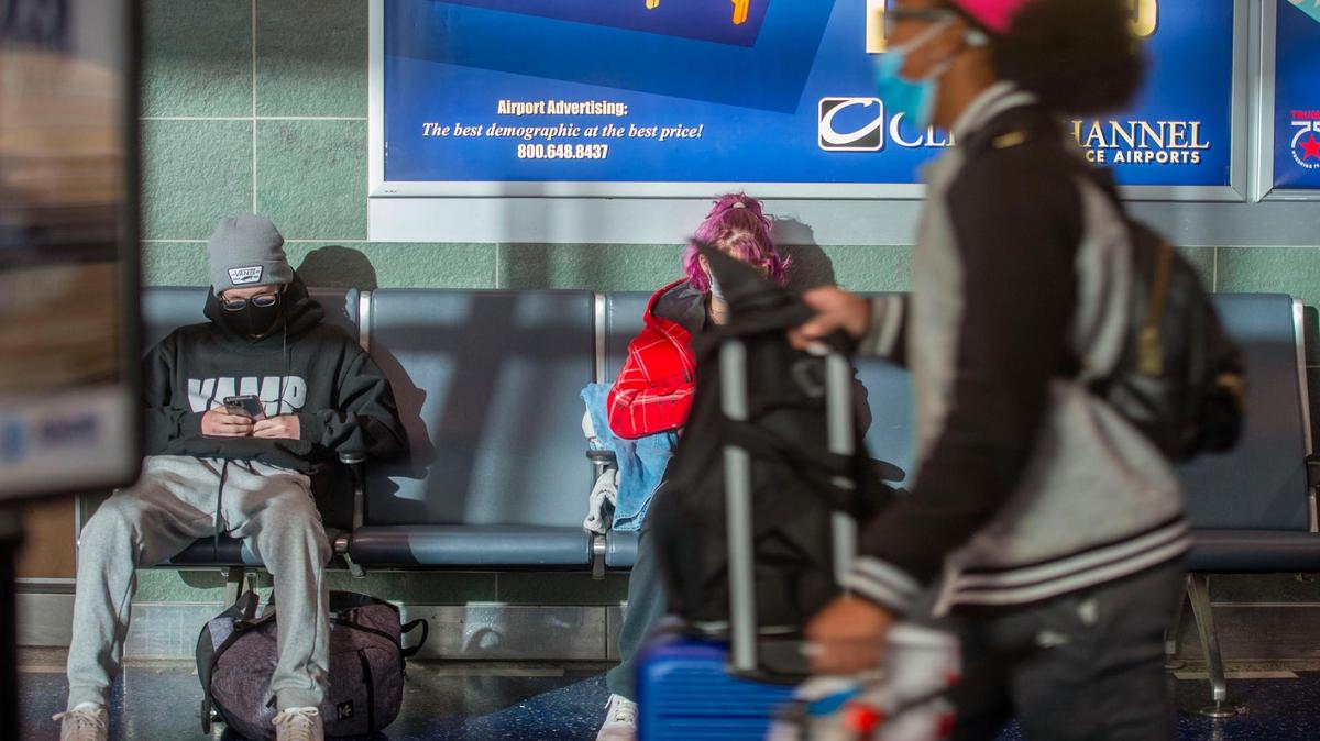 Holiday travelers wait to board their plane at Kansas City International Airport on Wednesday, Dec. 22, 2021.